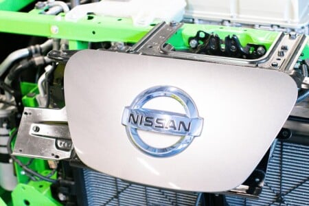 Nissan badge mounted on the front of car engine