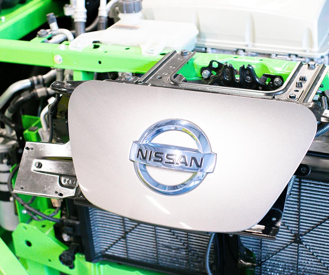 Nissan badge mounted on the front of car engine