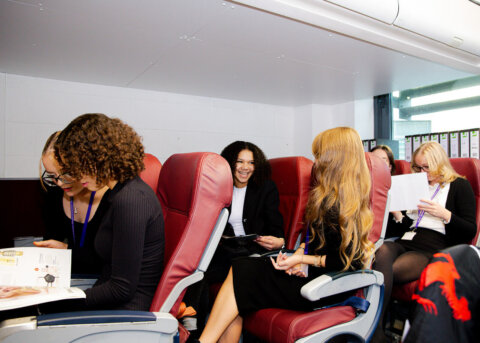 travel and tourism students sitting in staged plane passenger seating
