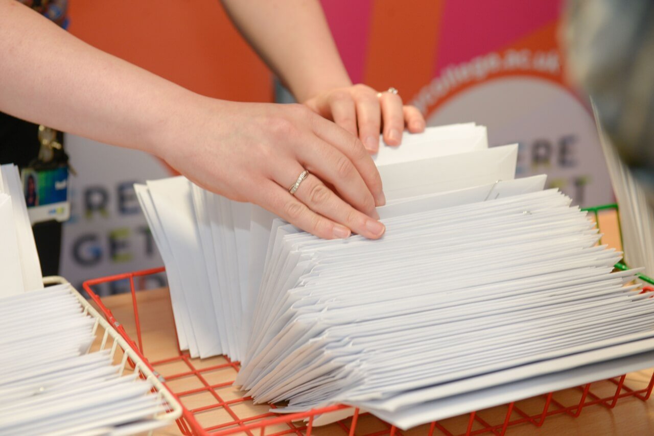 Staff member sorting through stack of envelopes
