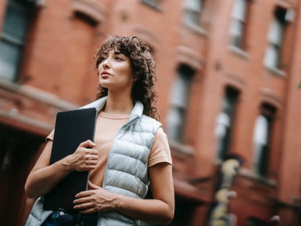 Woman holding tablet, standing in a street