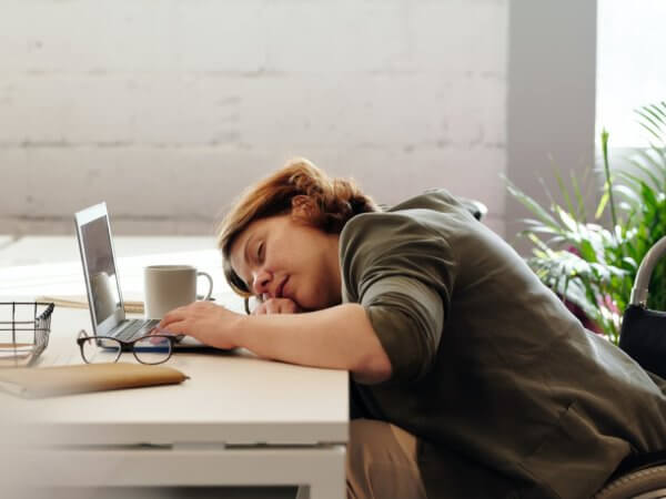 Woman asleep at desk with laptop