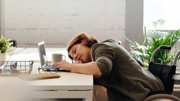 Woman asleep at desk with laptop