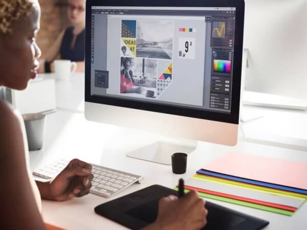 A woman using a desktop computer with a graphics tablet