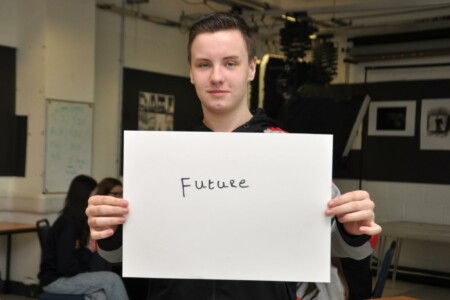 Student holding piece of paper with the word future written on it