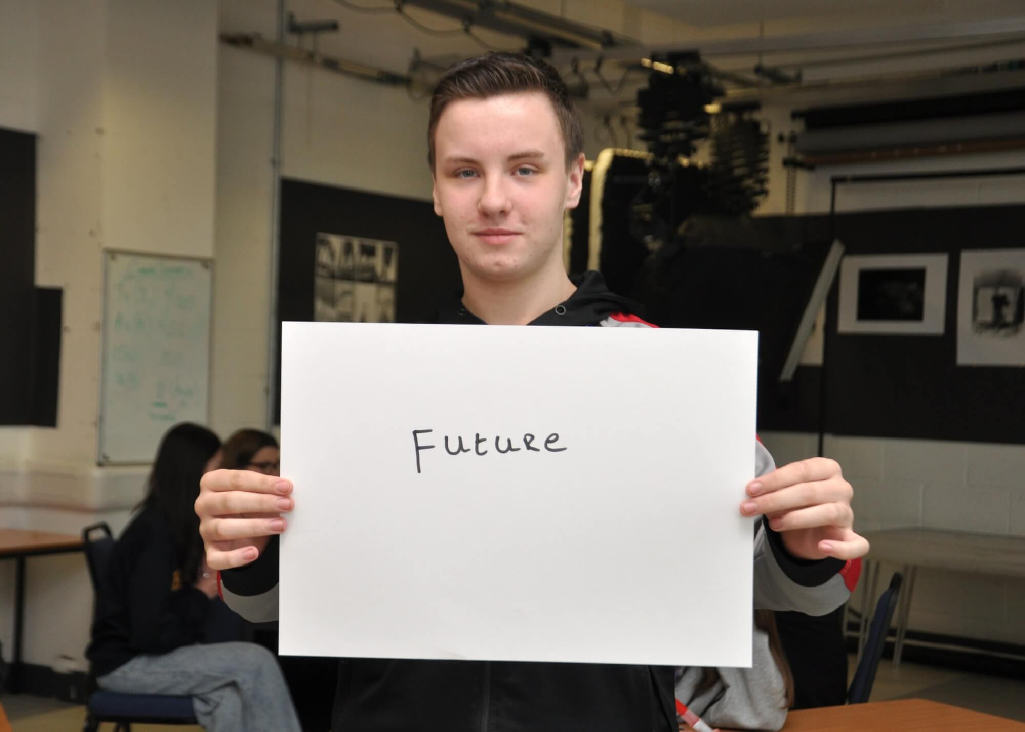 Student holding piece of paper with the word future written on it