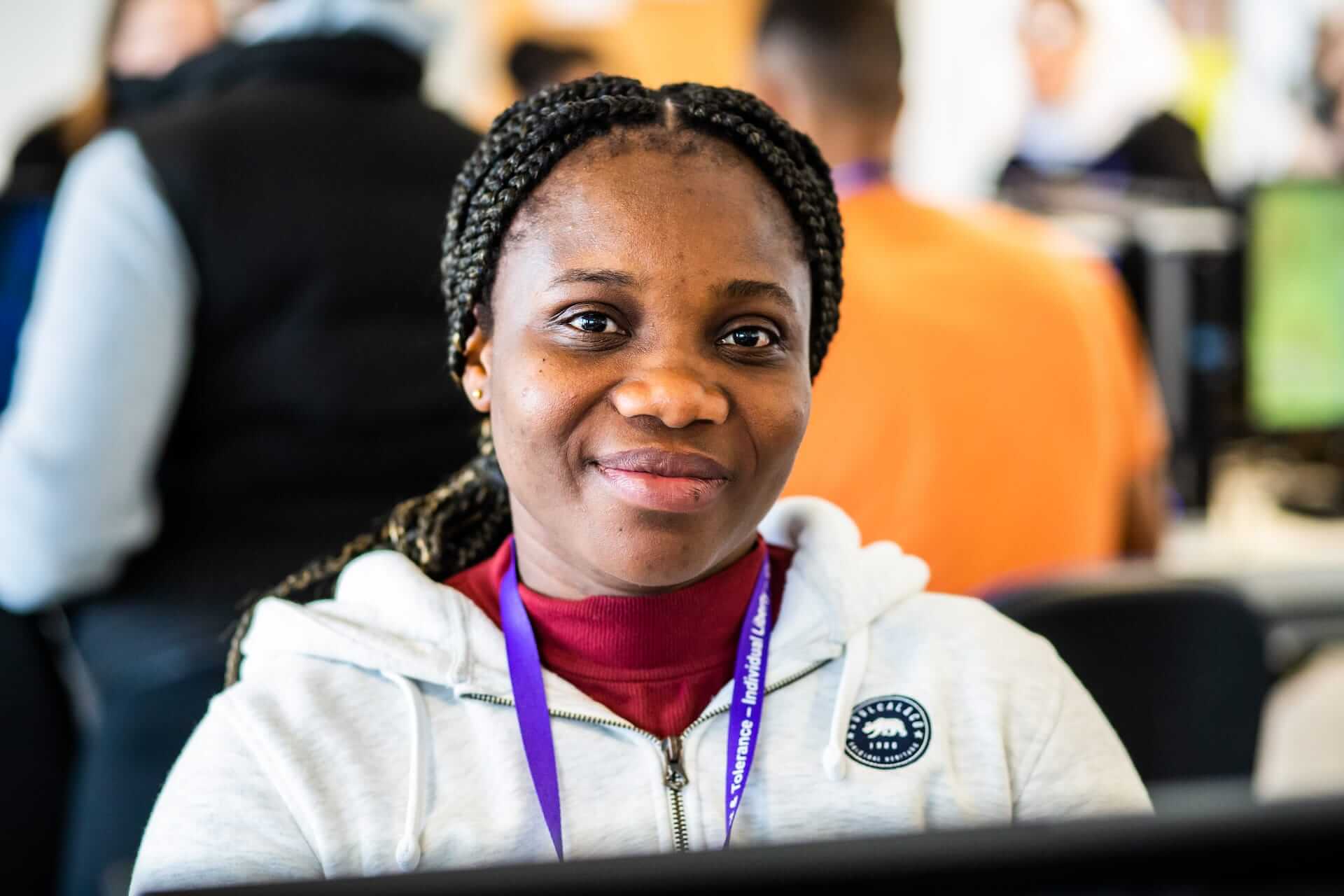 Close up of coventry college learner wearing a lanyard and sitting at computer desk
