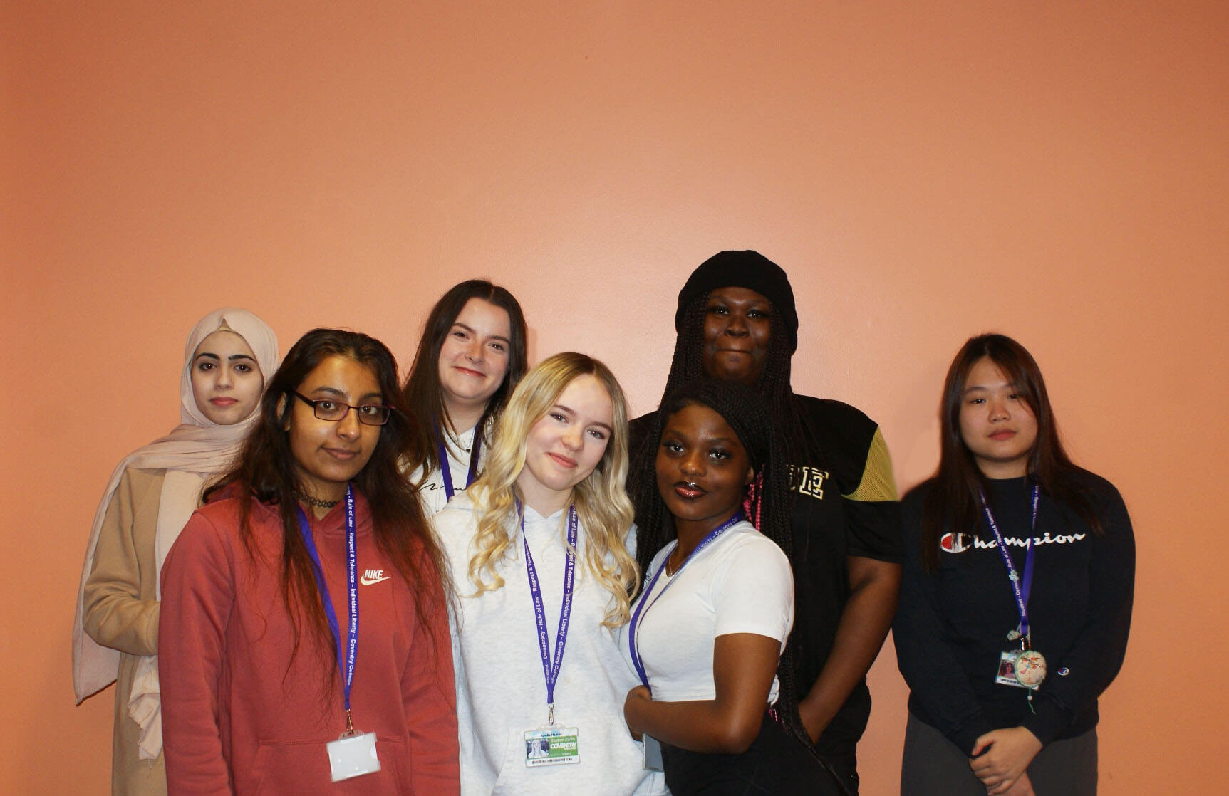 Group of Health and Social Care students standing in front of an orange background