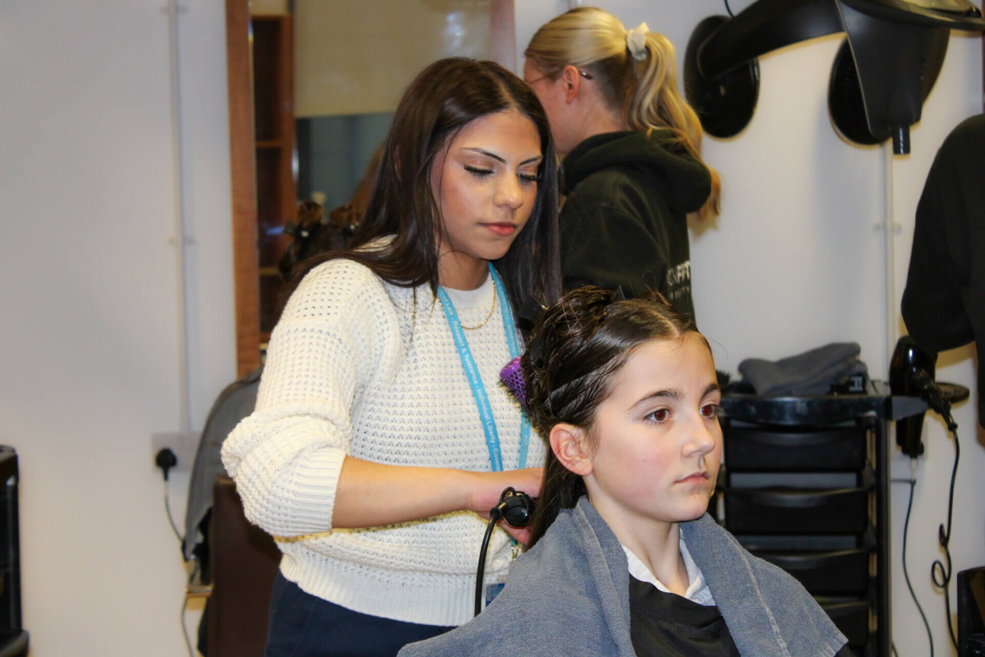 Hairdressing student styling child’s hair