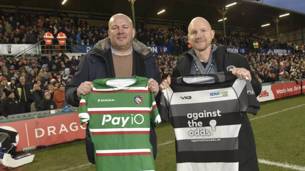 Representatives from Coventry College and Leicester Tigers holding rugby shirts
