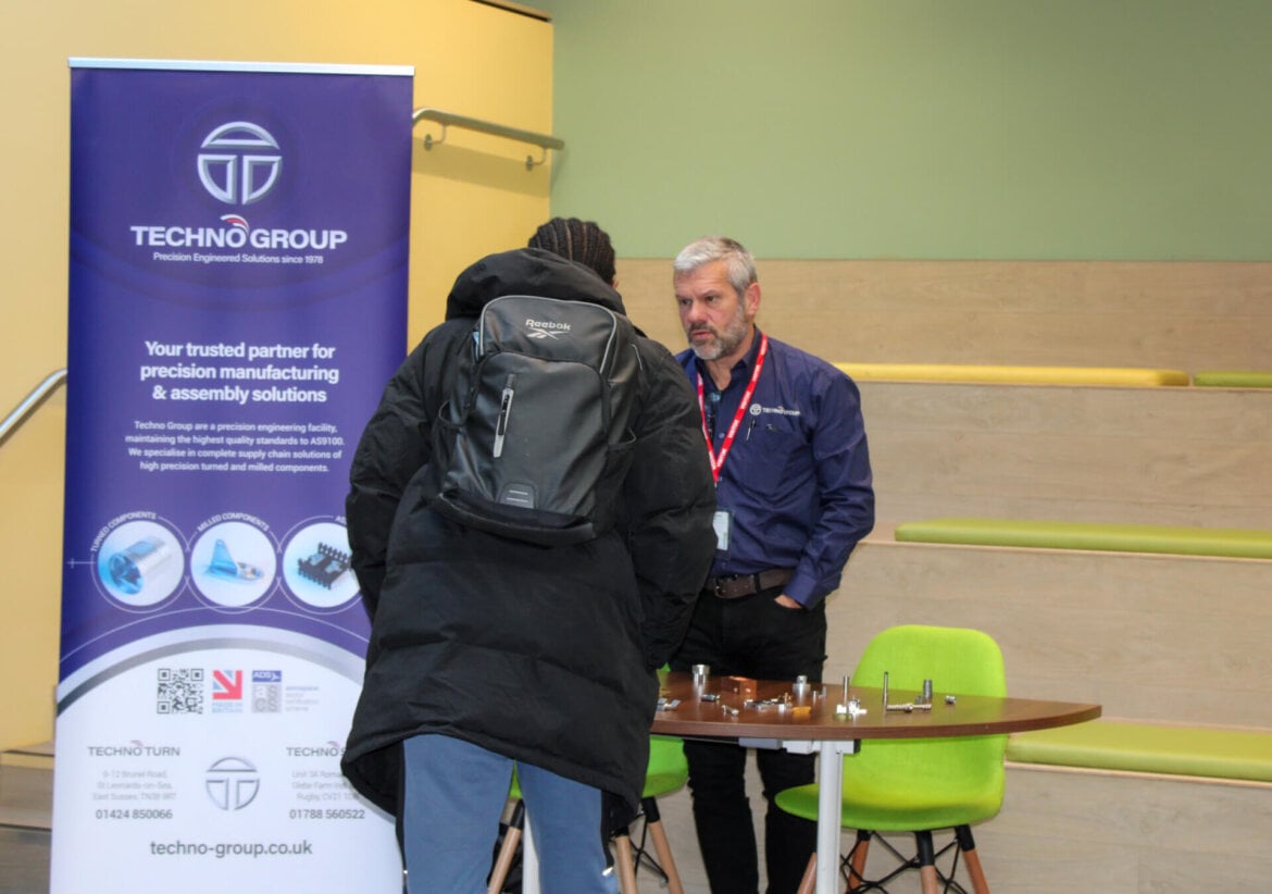 Techno Group employer talking to student