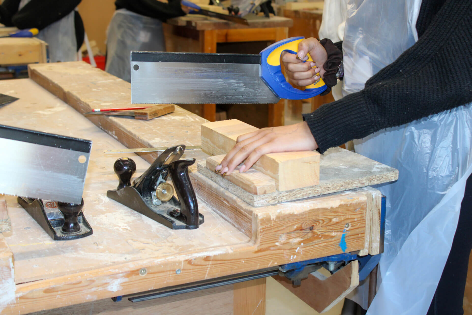 Female students participating in woodwork activity 