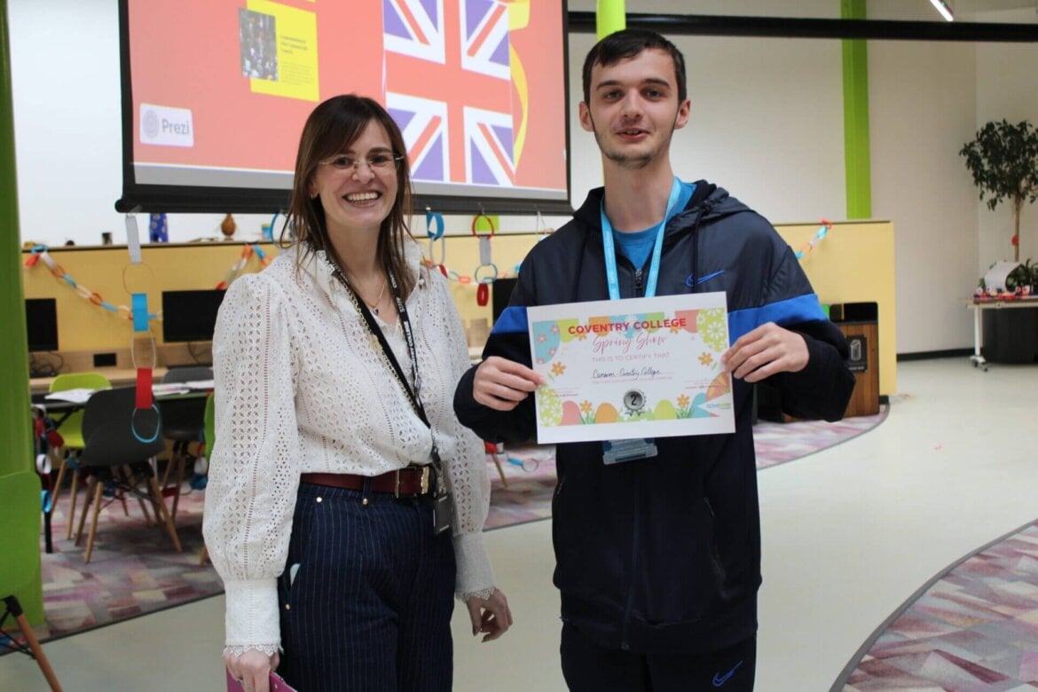 Foundation student holding certificate stood with staff member