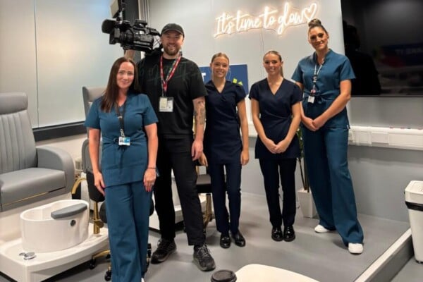 ITV cameraman stood with beauty students and staff