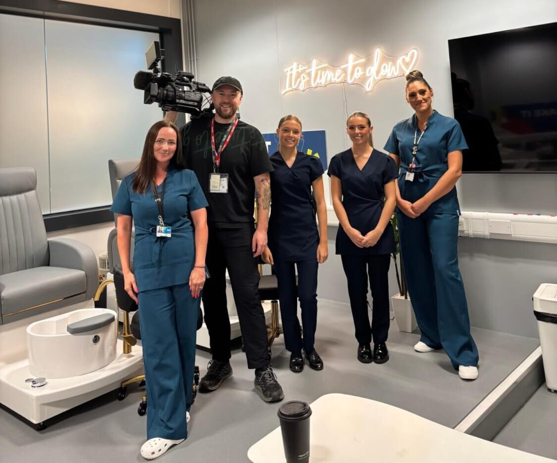 ITV cameraman stood with beauty students and staff