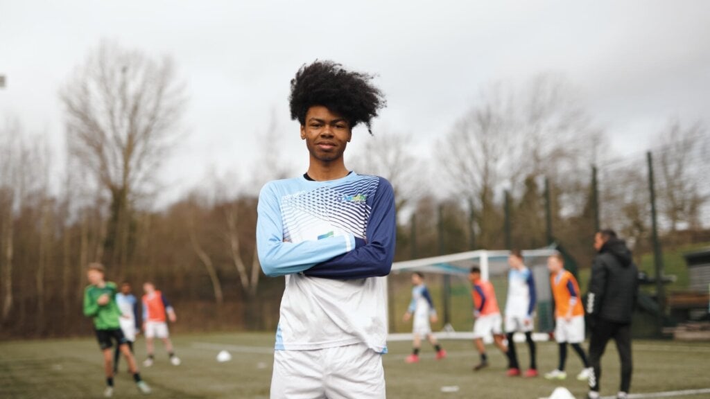 coventry college sports student in football kit standing on football pitch