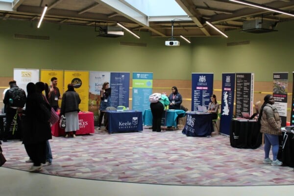 University staff talking to students at higher education fair