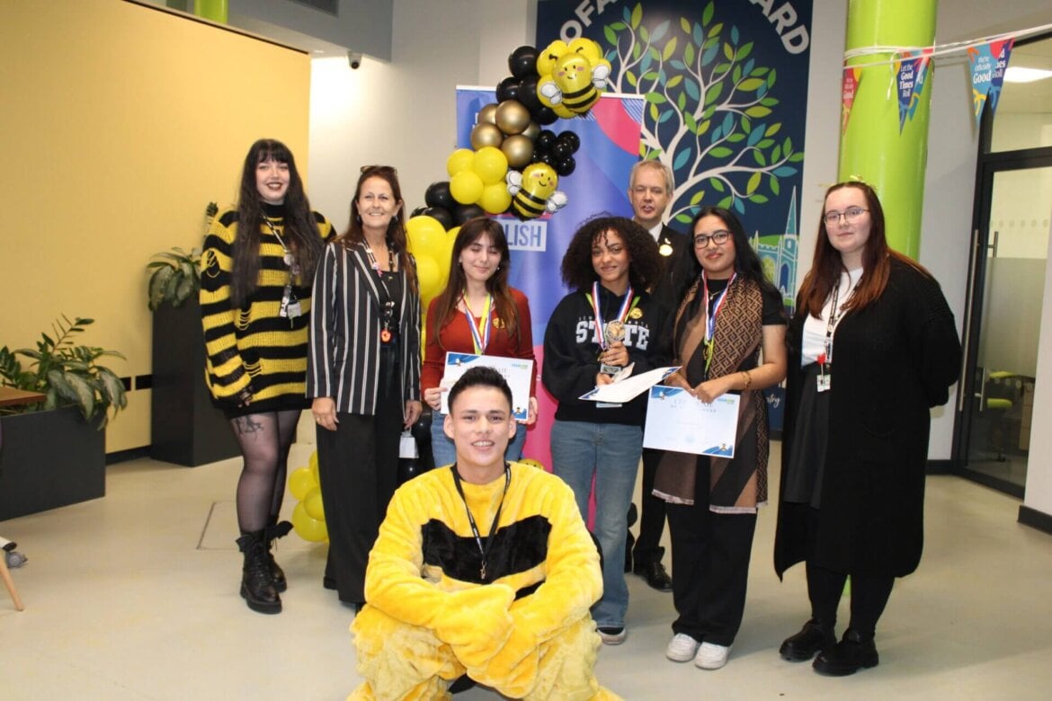 the winning team standing with Carol and staff member dressed as a bee