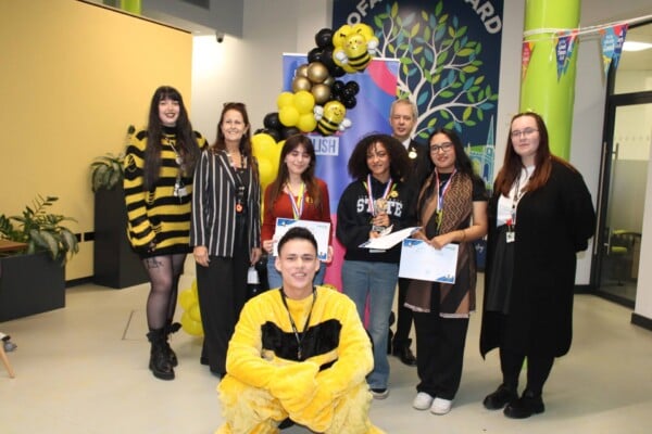 the winning team standing with Carol and staff member dressed as a bee