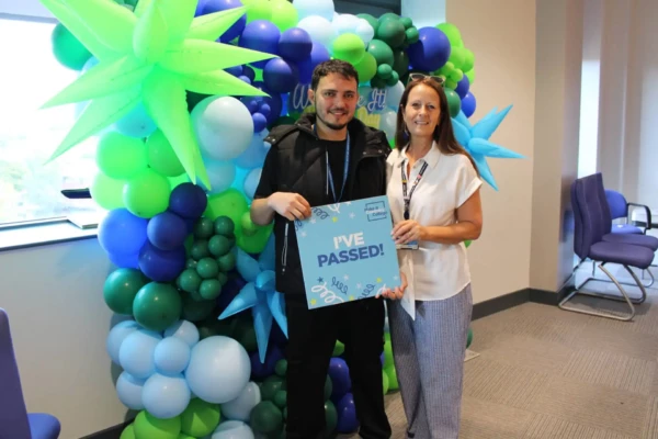 Student and Principal Carol Thomas stood in front of balloon display holding 