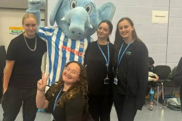 students posing with Sky Blue Sam